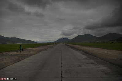 یک زن در امتداد جاده شمال شرقی پیونگ یانگ در حال حرکت