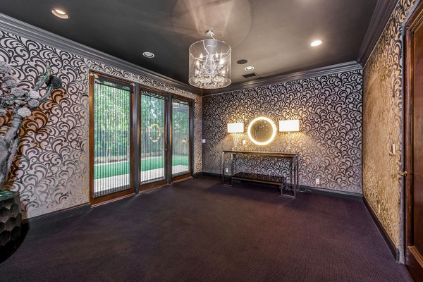 یکی از اتاق های طبقه پائین با کاغذدیواری طرح دار و گچ بری های شیک تزئین شده است.