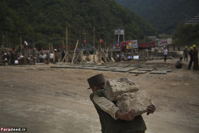 کارگر ساختمانی در حال حمل سنگ برای یک پروژه ساختمانی در 