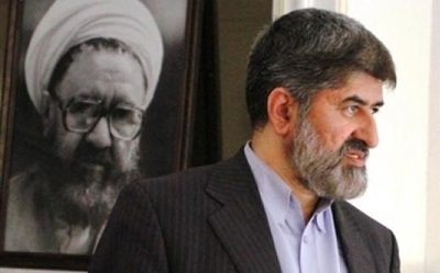 علی مطهری در کنار عکس مرحوم پدرش مرتضی مطهری